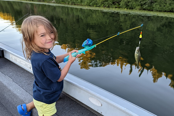 Child catches fish at Sleeping Fawn Resort near a Park Rapids Minnesota Hotel with great fishing